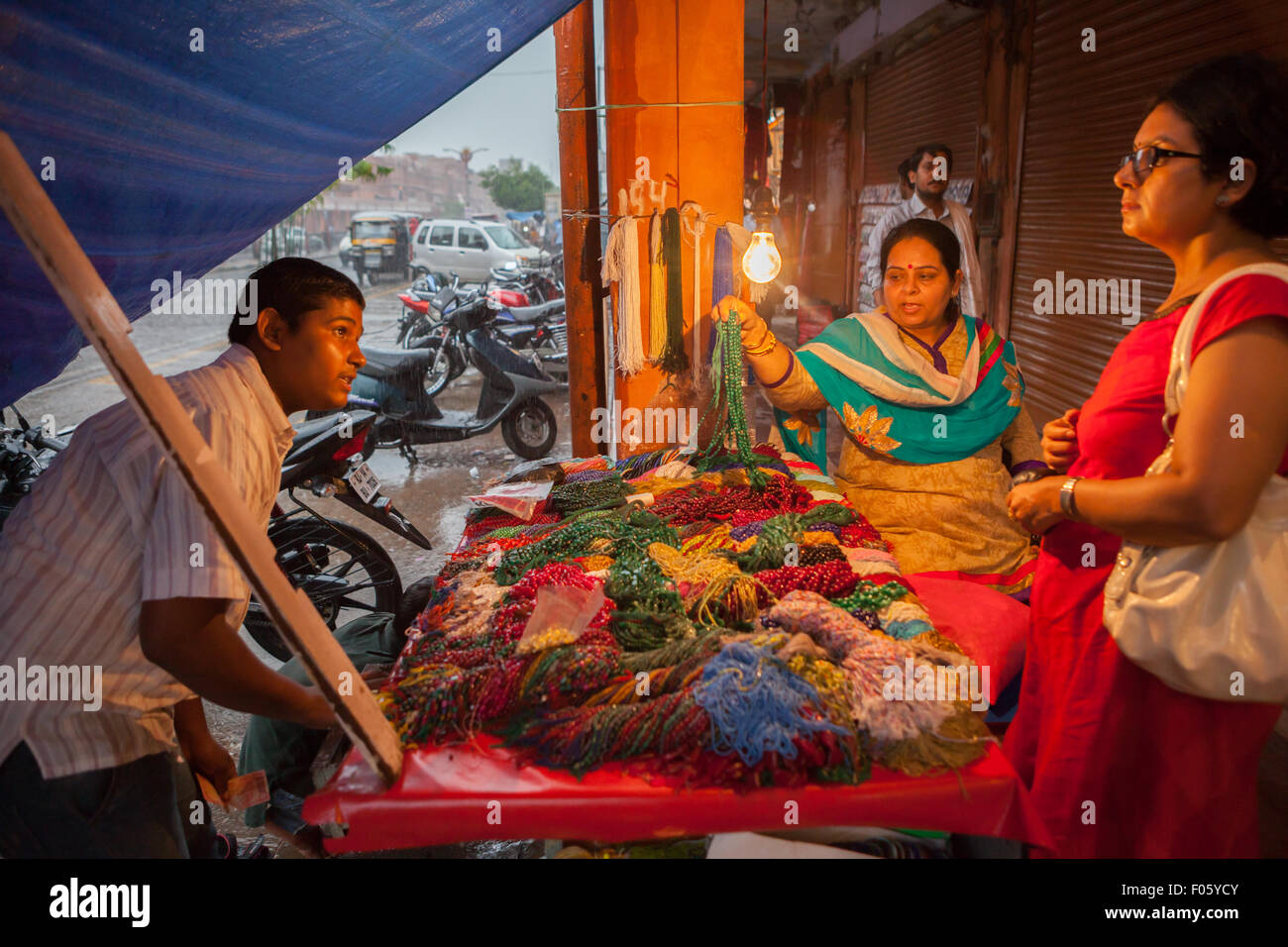 Frauen pflücken Halskette Perlen bei einem Straßenhändler in Jaipur, Rajasthan, Indien. Stockfoto