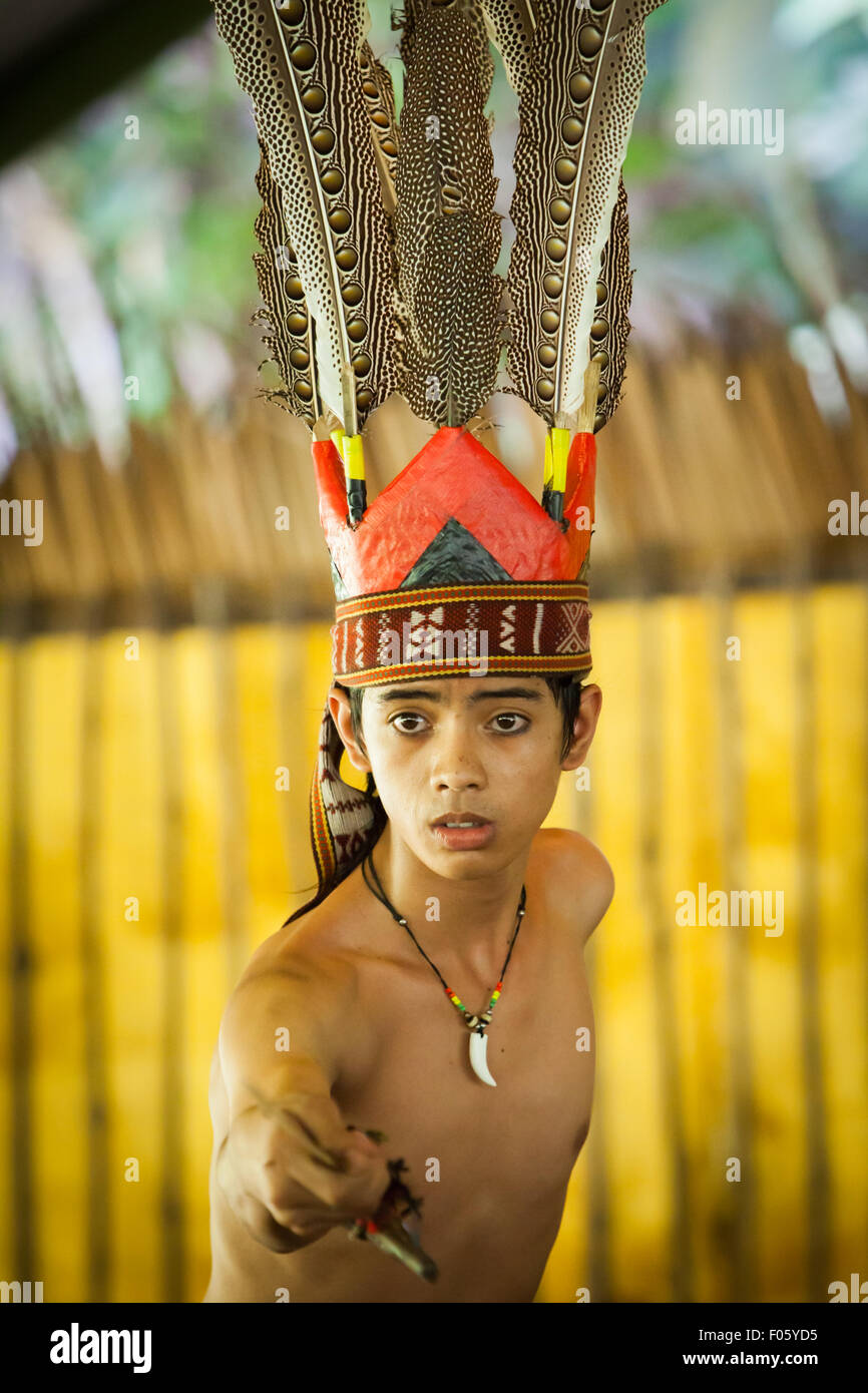 Portrait eines Tourismusarbeiters in indigener Kleidung während einer indigenen Tanzvorstellung für Touristen im Mari Mari Cultural Village, Sabah. Stockfoto
