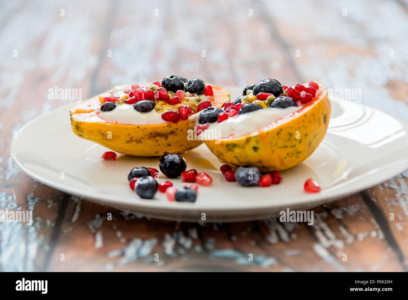 Papaya mit natürliche Soja-Joghurt und frischen Beeren, leichtes und gesundes Frühstück, Papaya, Heidelbeeren, Passionsfrucht, Granatapfel Stockfoto