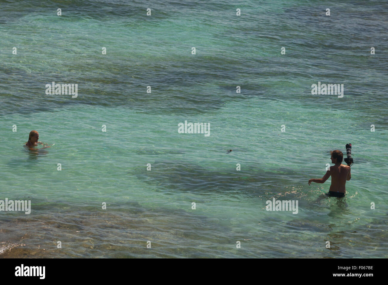 Touristen, die am flachen Wasser am Strand von Padang-padang, Labuan Sait, South Kuta, Badung, Bali, Indonesien. Stockfoto