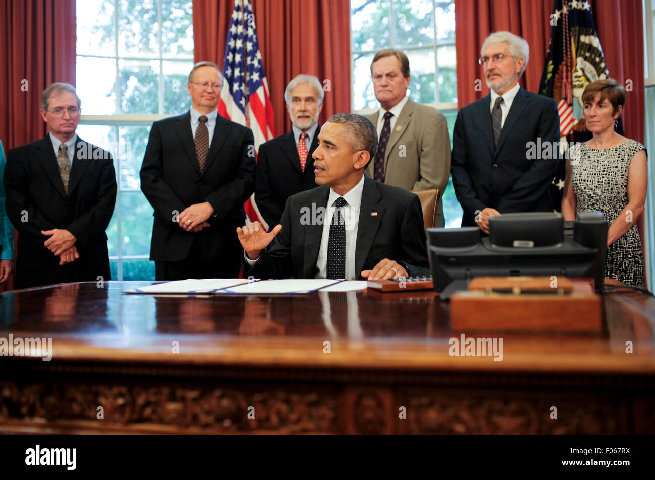 US-Präsident Barack Obama unterzeichnet Gesetz über den HR 1138 Sawtooth National Recreation Area und Jerry Peak Wilderness Ergänzungen im Oval Office des weißen Hauses, am 7. August 2015, in Washington, DC. Hinter ihm steht links von rechts sind Sekretär Sally Jewell, Department of Interior, (Useen), Steve Botti, Präsident des Rates, Stanley Stadtrat (L), Gary O'Malley, Executive Director, Sägezahn Gesellschaft (2L), Rick Johnson, Executive Director, Idaho Conservation League (3L), Vertreter Michael Simpson, R -ID (3R), Craig Gehrke, Idaho Regional Director, The Wilderness Society (2R), Ma Stockfoto