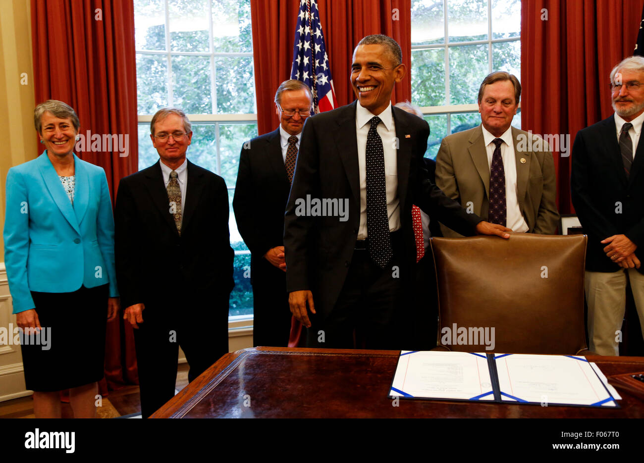 US-Präsident Barack Obama unterzeichnet Gesetz über den HR 1138 Sawtooth National Recreation Area und Jerry Peak Wilderness Ergänzungen im Oval Office des weißen Hauses, am 7. August 2015, in Washington, DC. Hinter ihm steht links von rechts sind Sekretär Sally Jewell, Abteilung des inneren, (L), Steve Botti, Präsident des Rates, Stanley Stadtrat (2L), Gary O'Malley, Executive Director, Sägezahn Gesellschaft (3L), Rick Johnson, Executive Director, Idaho Conservation League (unsichtbaren), Vertreter Michael Simpson, R -ID (2R), Craig Gehrke, Idaho Regional Director, The Wilderness Society (R), Ma Stockfoto