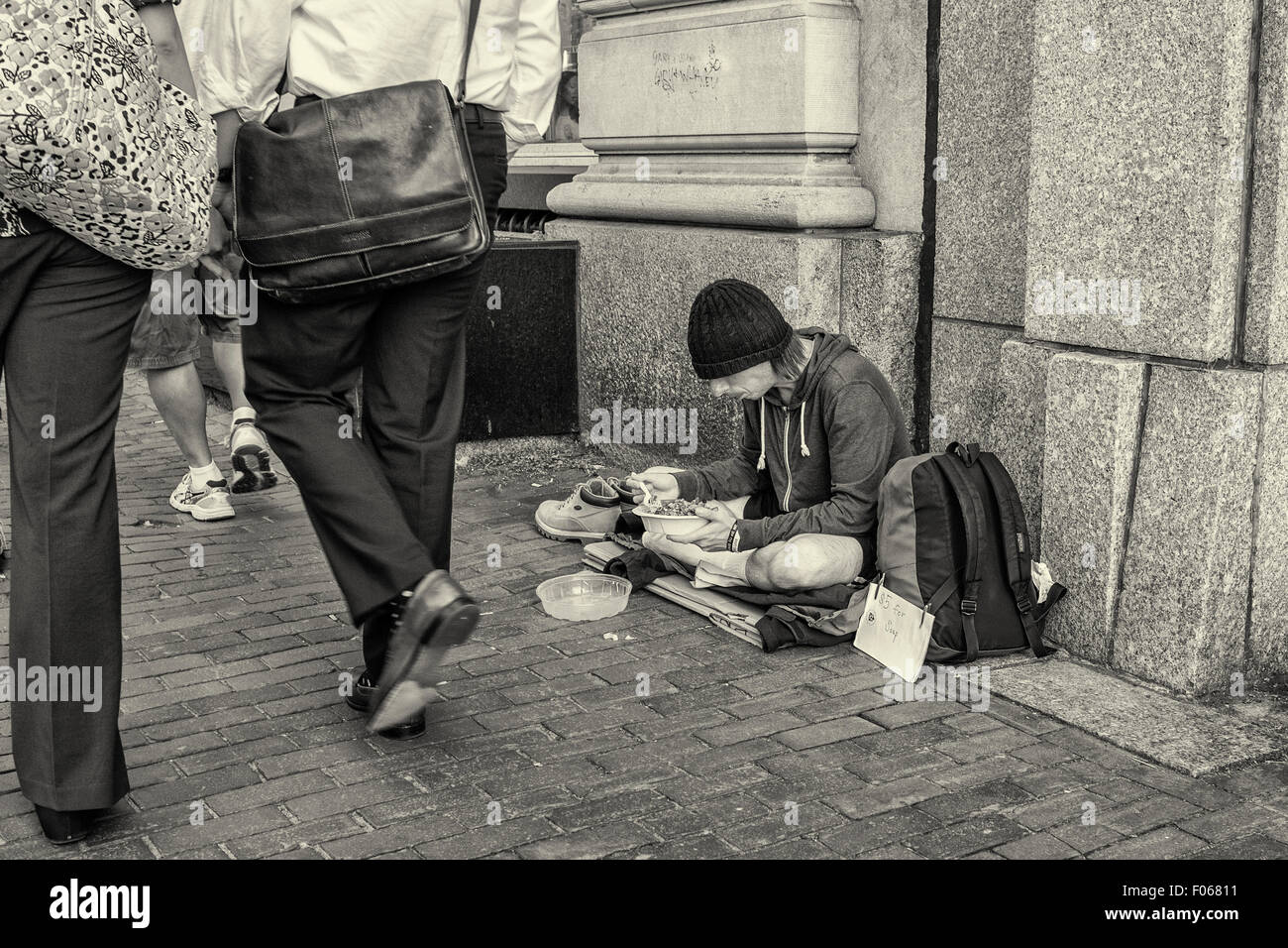 Obdachloser Essen auf dem Bürgersteig in Cambridge, MA Stockfoto