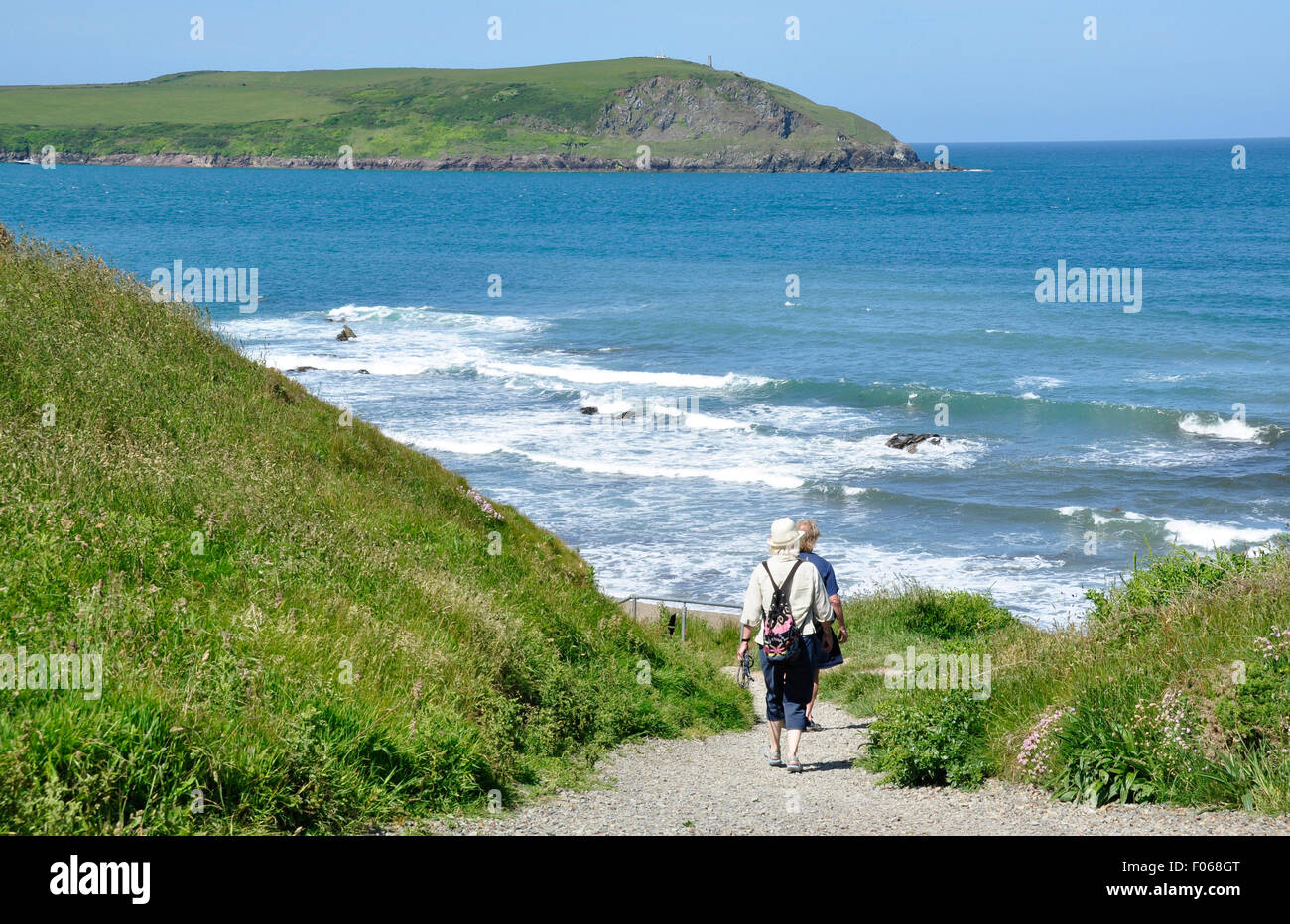 North Cornwall - Klippe Top - Strand Greenaway - paar zu Fuß weg - White crest Breakers - blaue Meer/Himmel Stockfoto