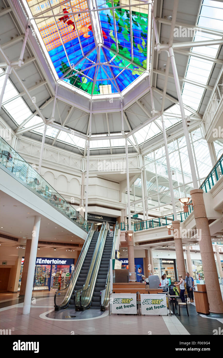 Spindeln Stadt Einkaufszentrum Rolltreppen Frau Mama Kinderwagen schieben verzierten Features Atrium Glas innen überdachte Einkaufszentrum mit Stockfoto