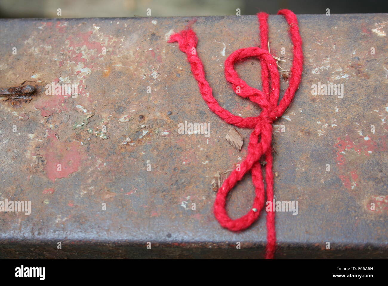 Roten String auf der verwitterten Sitzbank gefesselt. Stockfoto