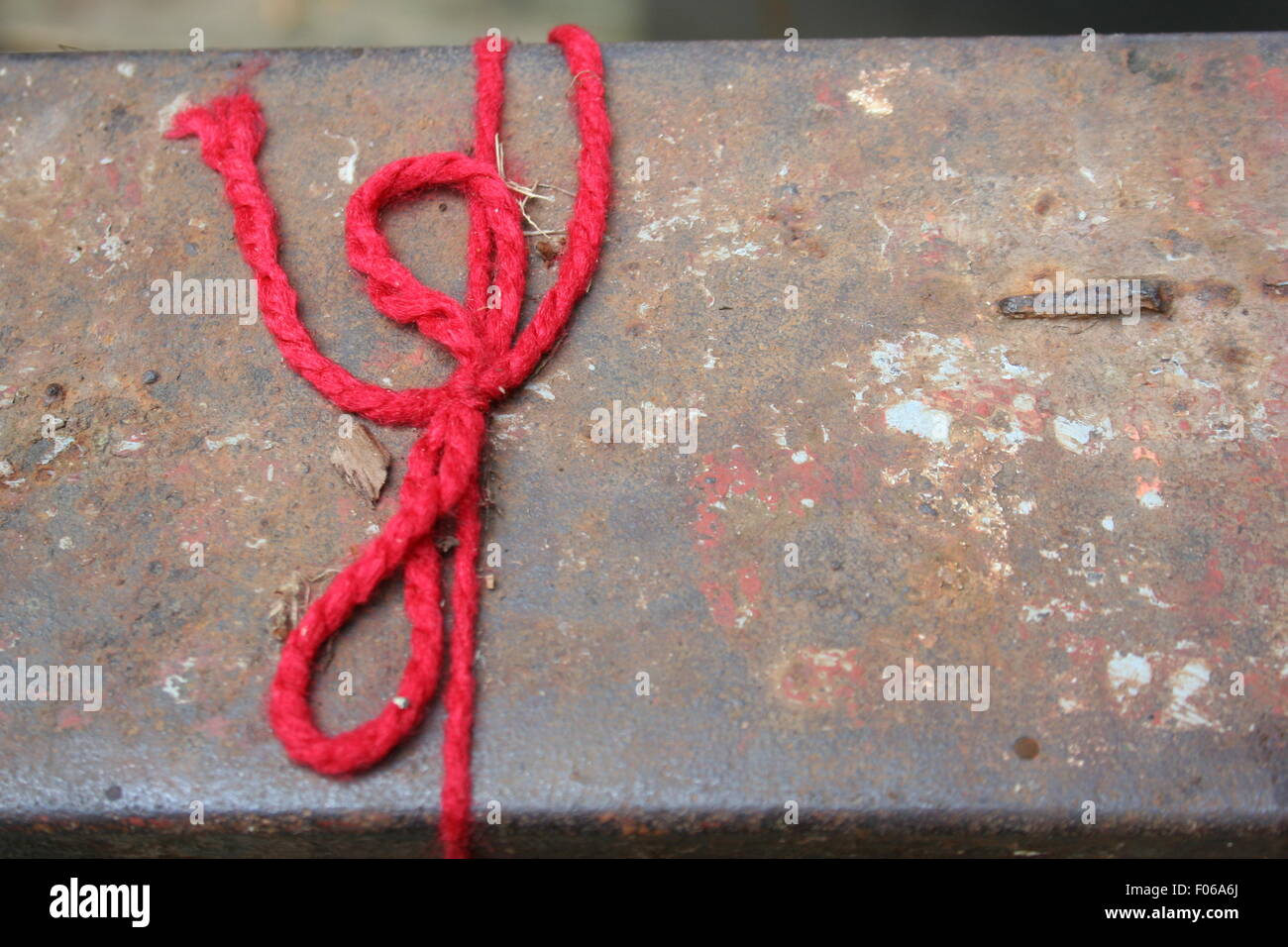 Roten String auf der verwitterten Sitzbank gefesselt. Stockfoto