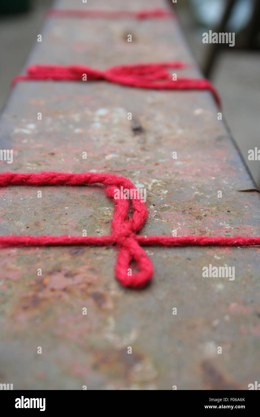 Roter String Bogen auf einer verwitterten Bank. Stockfoto