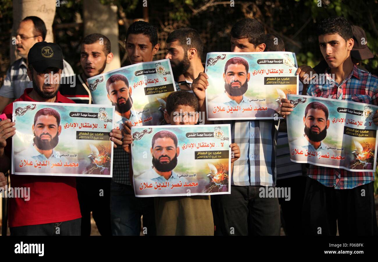 Gaza-Stadt, Gazastreifen, Palästinensische Gebiete. 8. August 2015. Demonstranten halten Porträts des palästinensischen Gefangenen in israelischen Gefängnissen Mohammad Allan, während einer Protestaktion außerhalb der Vereinten Nationen in Gaza-Stadt am 8. August 2015 Hauptsitz. Der israelische Militärstaatsanwalt Gericht Genehmigung am Samstag für Hungerstreikenden Gefangenen Mohammad Allan, der palästinensische Minister für die Angelegenheiten, zu mästen beantragen will mitteilte Issa Qaraqe am Freitag. Allan, ein Anwalt aus dem besetzten Westjordanland Stadt Nablus, ist seit mindestens 50 Tage aus Protest gegen seine Inhaftierung ohne Anklage oder Tri im Hungerstreik Stockfoto