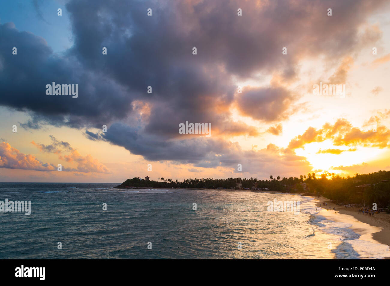 Goldener Sonnenuntergang am einsamen Strand mit bunten Himmel und malerische Wolkengebilde während der Monsunzeit. Urlaubsort in Unawatuna, Sri Lank Stockfoto