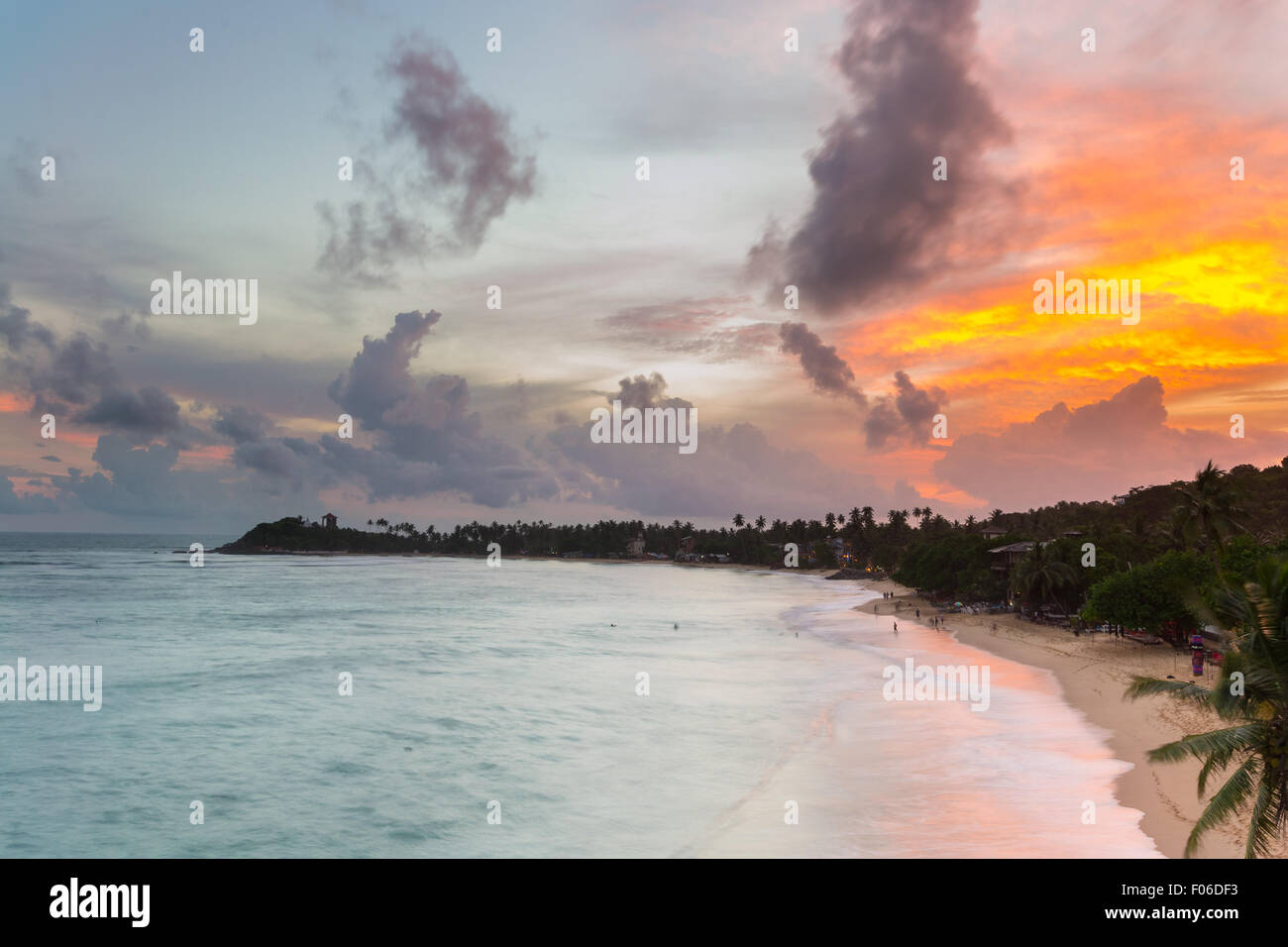 Goldener Sonnenuntergang am einsamen Strand mit bunten Himmel und malerische Wolkengebilde während der Monsunzeit. Urlaubsort in Unawatuna, Sri Lank Stockfoto