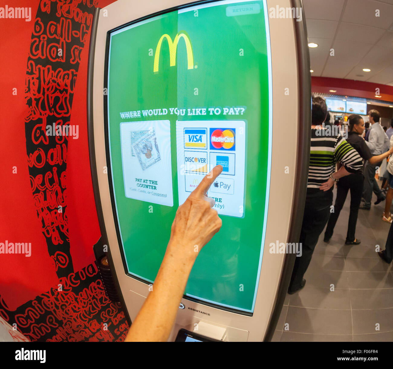 Eine Diner wählt ihre Zahlungsmethode an einem Kiosk "Erstellen Sie Ihren Geschmack" bei McDonald's in New York im Dienstag, 4. August 2015. Die interaktive iPad-ähnliche Digitalanzeigen erlauben es Kunden, ihren Auftrag mit Belag, neue Soßen usw. anpassen und haben sie in wenigen Minuten an ihrem Tisch geliefert. McDonald's, die same-Store-Umsatzrückgang innerhalb von drei Jahren gesehen hat, nutzt die Kioske mit fast-casual Restaurants wie Chipotle, Fatburger und eine Vielzahl von anderen zu konkurrieren. (© Richard B. Levine) Stockfoto