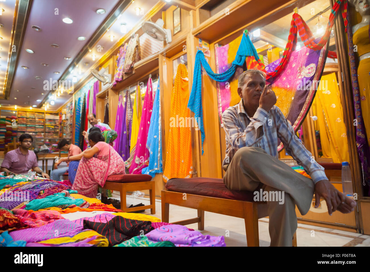 Ein Mann, der in einem Damenmodegeschäft in Jaipur, Rajasthan, Indien, sitzt. Stockfoto