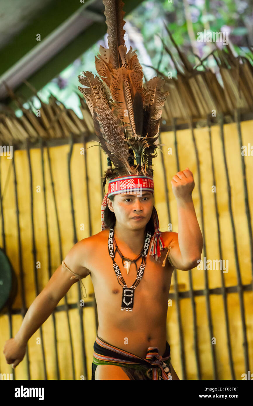 Portrait eines Tourismusarbeiters in indigener Kleidung während einer indigenen Tanzvorstellung für Touristen im Mari Mari Cultural Village, Sabah. Stockfoto