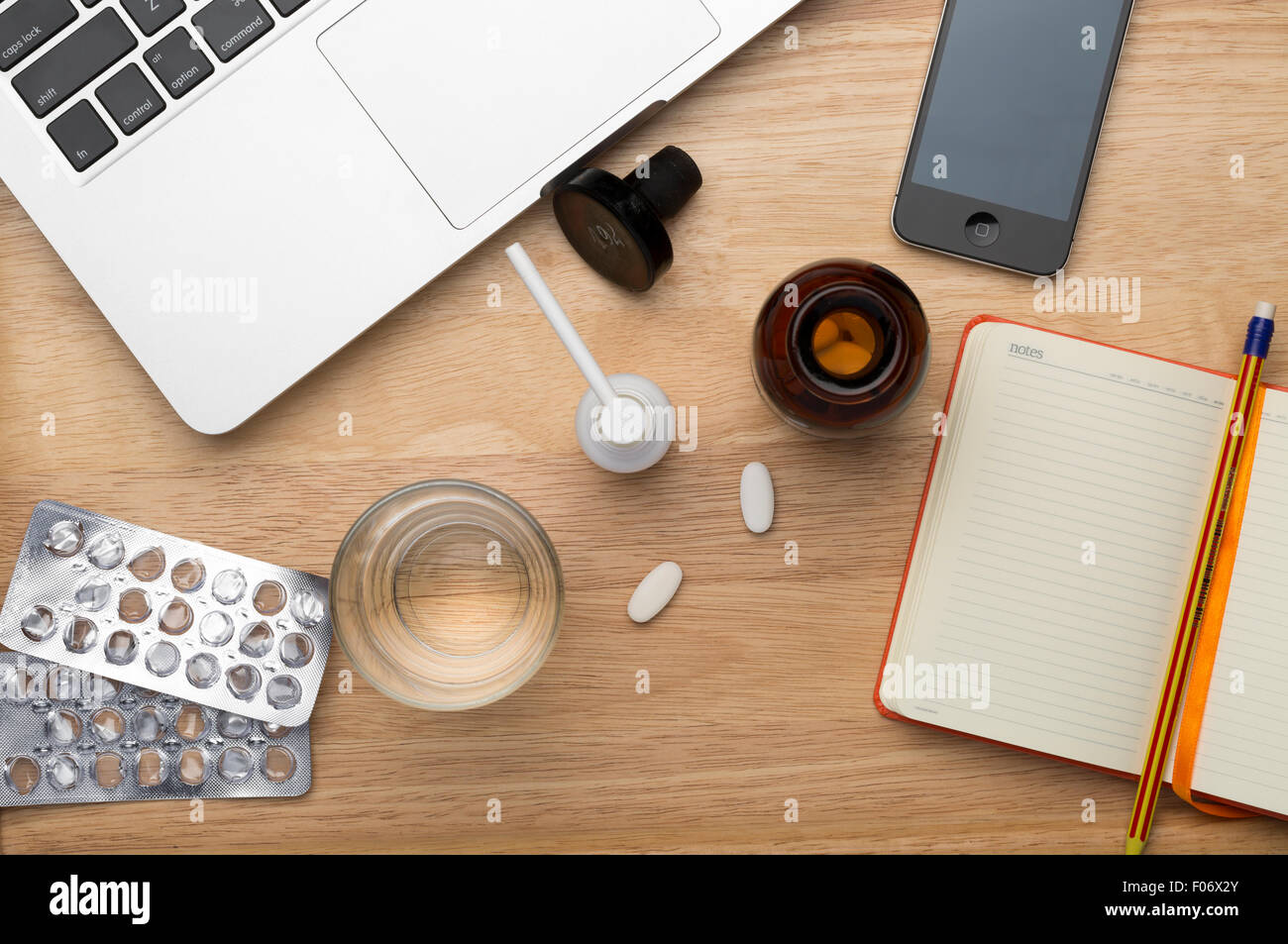 Laptop, Handy und Pillen und Glas Wasser Stockfoto