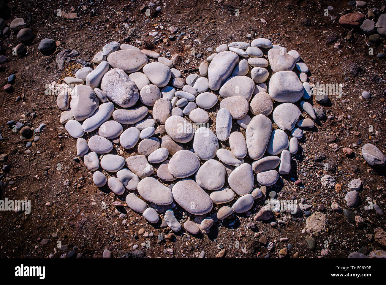 Herzförmige Design aus Kieselsteine am Strand Stockfoto