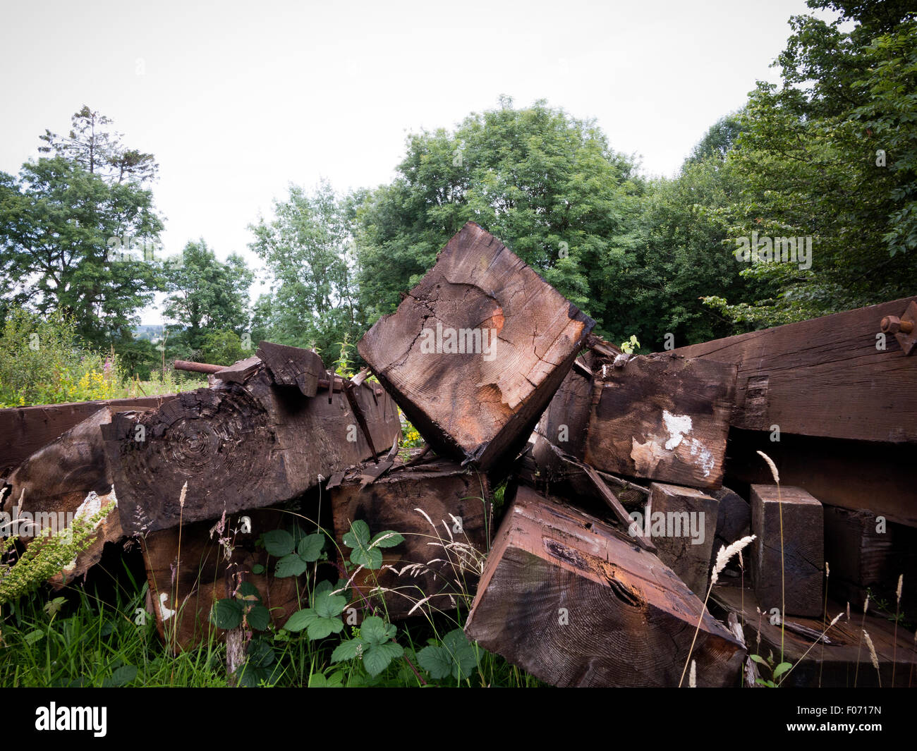 Ausgediente Eisenbahnschwellen gestapelt auf dem Rasen in einer ländlichen Gegend Stockfoto