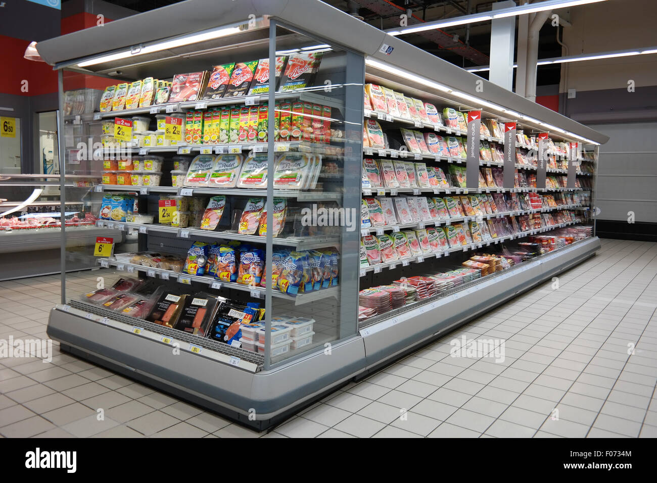 Kühlschrank gefüllt mit verarbeitete Fleischprodukte aus einem Carrefour-Supermarkt. Stockfoto