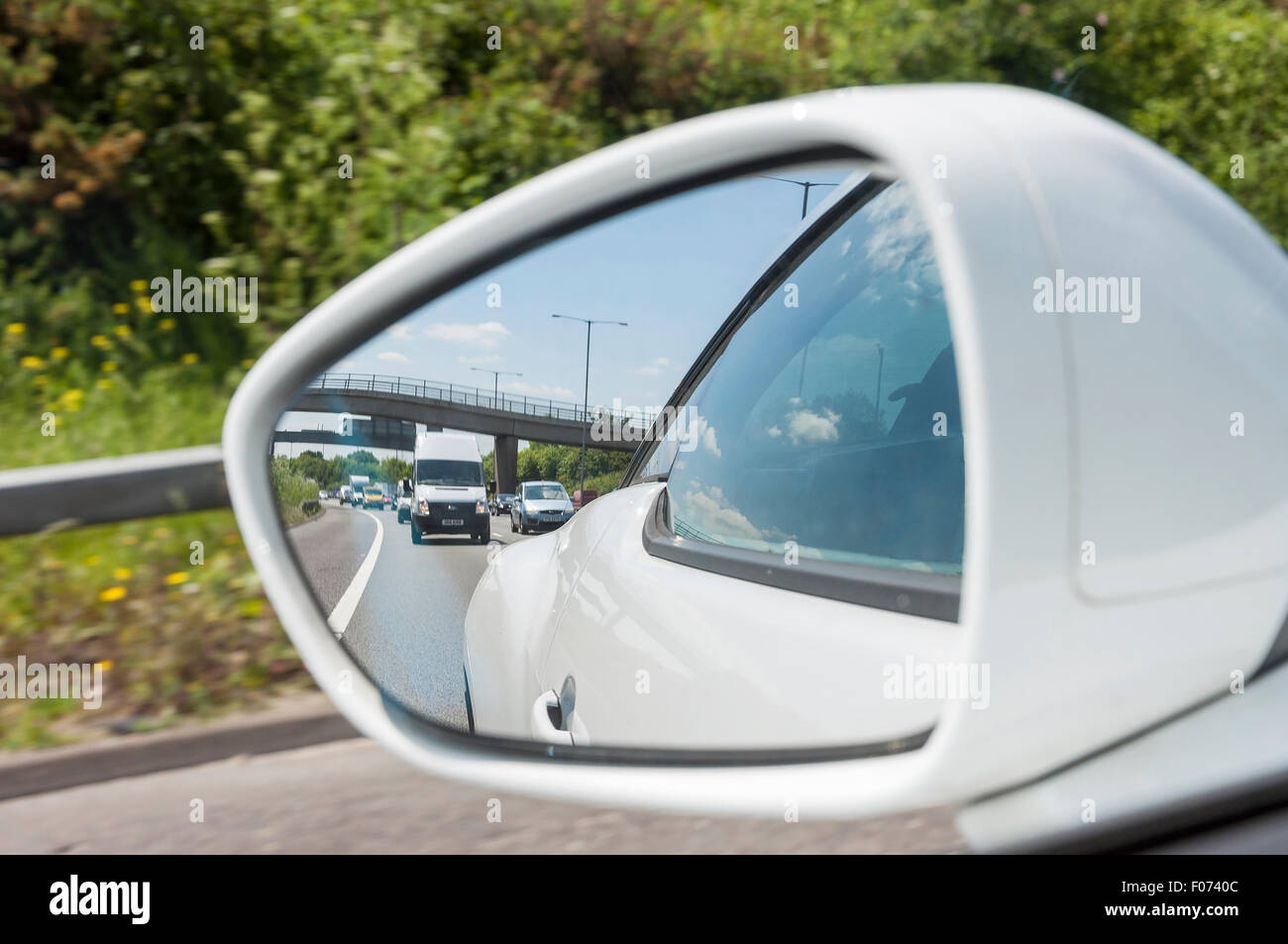 Spiegelnde Straße im Rückspiegel. Blick vom Auto Seitenspiegel