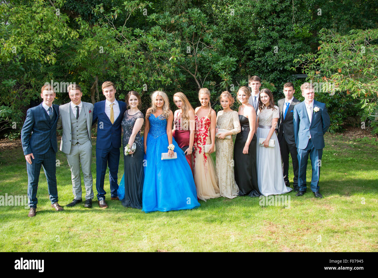 Gruppe von Teenager-Jungen und Mädchen posiert in Prom Kleid, Englefield Green, Surrey, England, Vereinigtes Königreich Stockfoto