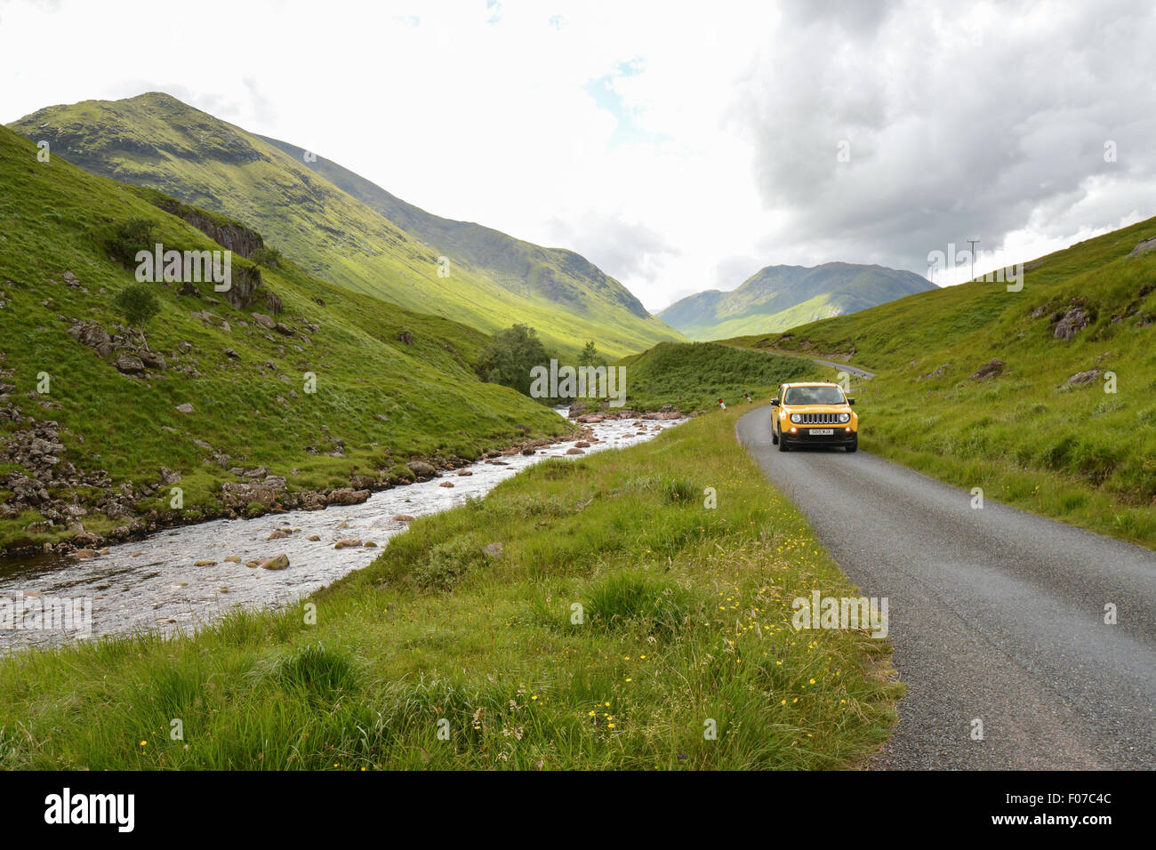 Gelben Jeep Fahrt entlang der einspurigen Straße durch Glen Etive, in der Nähe von Glencoe in den schottischen Highlands Stockfoto