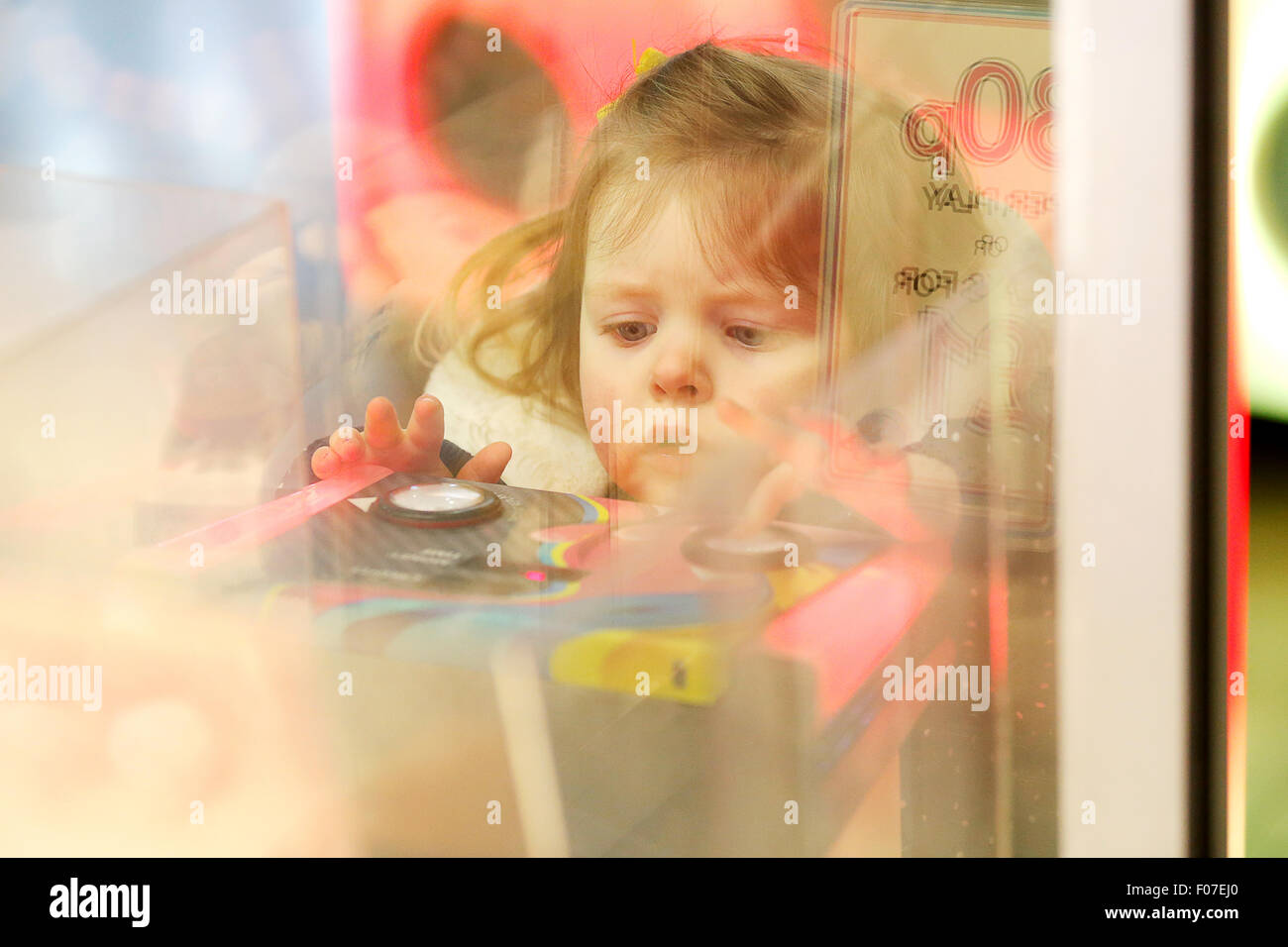 Ein Kind spielt auf einer Spielhalle Maschine Stockfoto