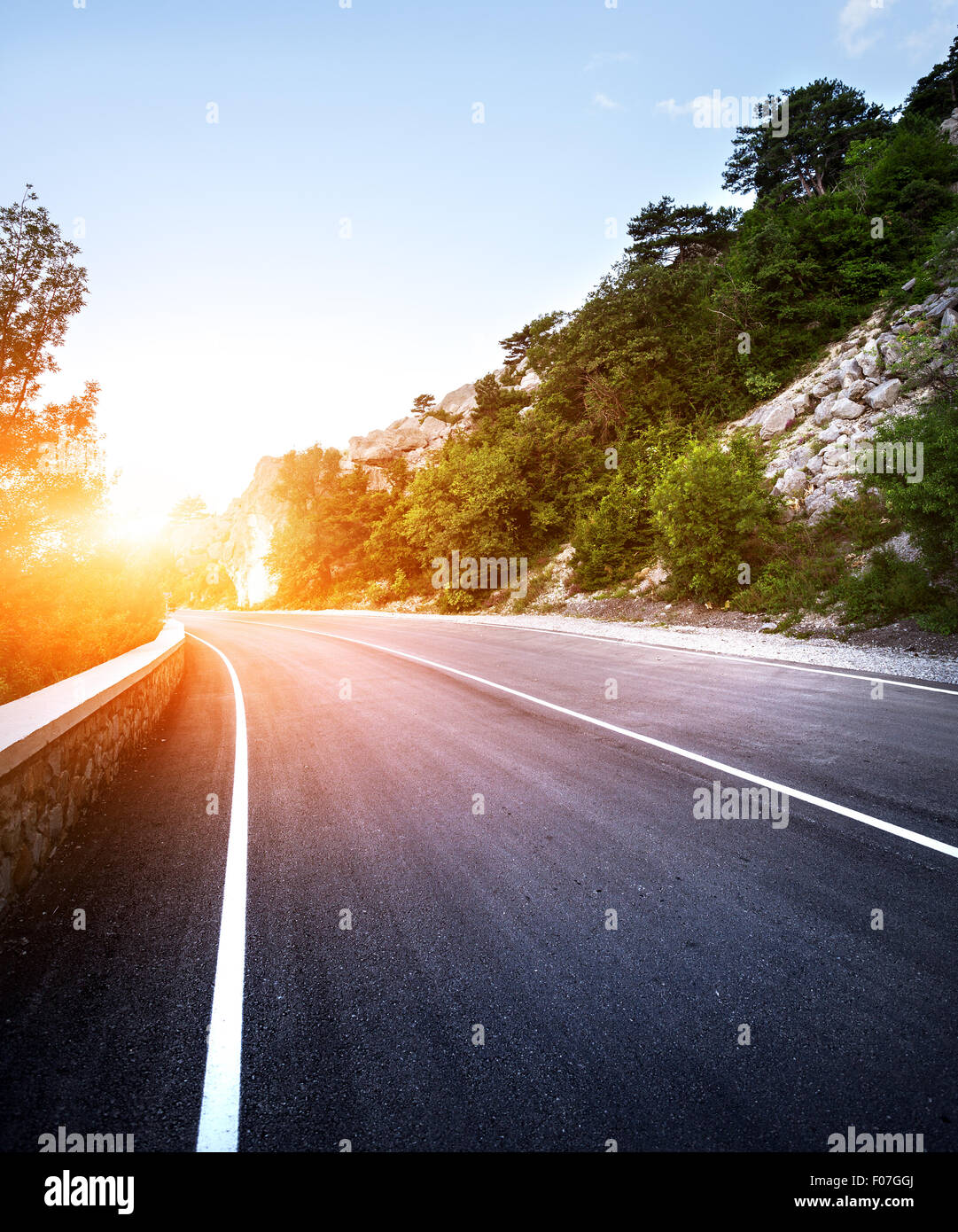 Asphaltierte Straße im Sommer Wald bei Sonnenuntergang. Krimberge. Stockfoto