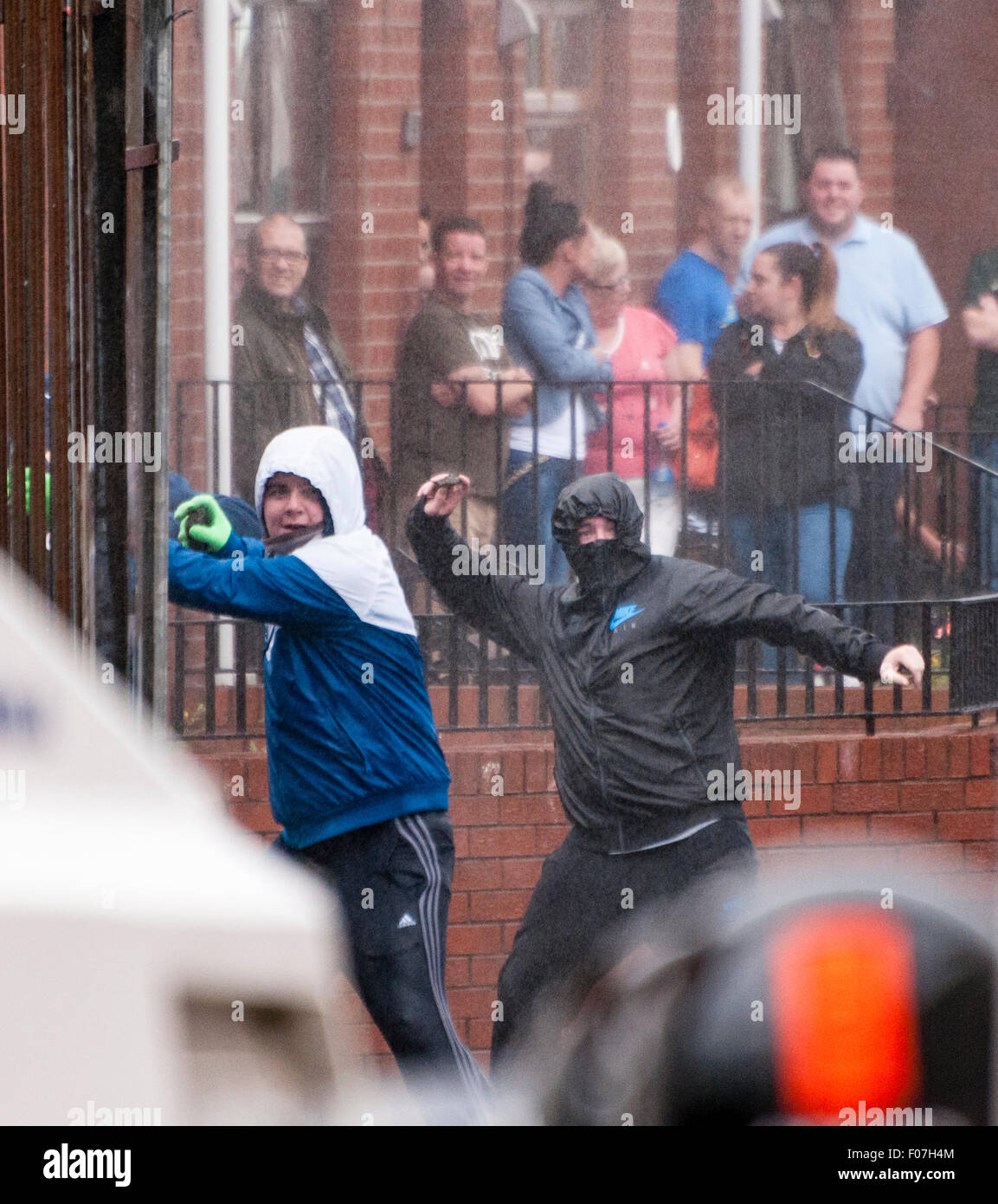 Belfast, Nordirland. Werfen Sie 9. August 2015 - zwei nationalistische Jugendliche, mit Steinen in PSNI Offiziere nach einem Anti-Internierung-Rallye. Bildnachweis: Stephen Barnes/Alamy Live-Nachrichten Stockfoto