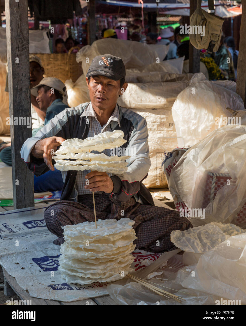 Kreditor an Nam Pan fünftägige Markt Stapeln Papadams auf eine Spitze vor Kunststoff wickelte sie für Bootstransport über Inle See Stockfoto