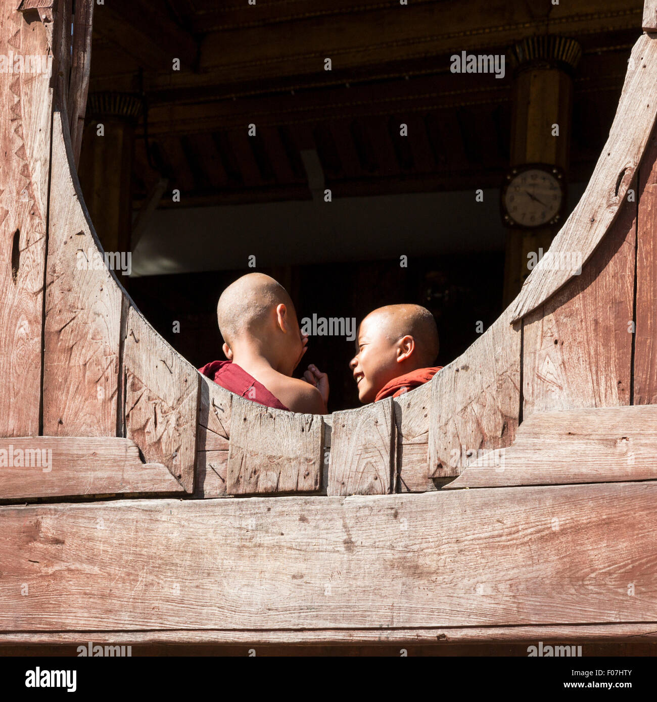 Zwei junge Mönche, eingerahmt in ein rundes Fenster im Shwe Yaunghwe Kyaung Kloster Shwe Nyaung, Shan State in Myanmar Stockfoto