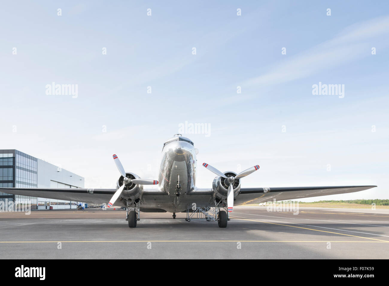 Bild von einem kleinen silbernen Flugzeug mit zwei Propellern geparkt in einem Flughafen an einem sonnigen Tag Stockfoto