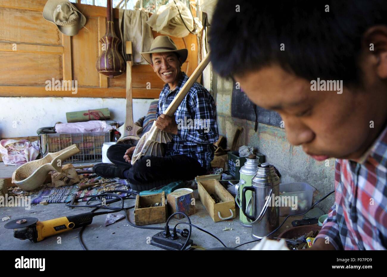(150810)--LHASA, 10. August 2015 (Xinhua)--46-j hrige Handwerker Uhren Dainzin (hinten) seinen Sohn tibetischen Instrument Dramyin in Lhasa, der Hauptstadt der Südwesten Chinas Tibet autonome Region, 9. August 2015 zu machen. Dramyin, ein 6-saitige Instrument spielt, ist eine alte tibetische gerupft Instrumente. Es ist ein lang-necked, Doppel-taillierte und fretless Laute. Es ist in der Regel aus einem einzigen Stück Holz ausgehöhlt und in der Größe von 60 bis 120 Zentimeter in der Länge variieren kann. Im Jahr 2014 hat die Herstellung von Draymin als einer von Chinas nationale immaterielle Kulturerbe eingetragen worden. (Xinhua/Jigme Dorje) (Zhs/Lfj) Stockfoto