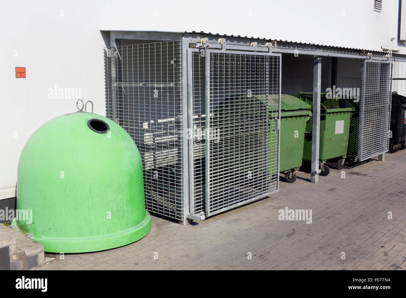 Tanks für die Verschwendung von Lebensmitteln in der Nähe eines Supermarkts. Stahl-Gitter schützen Container vor hungrigen Bettler und Bums. Stockfoto