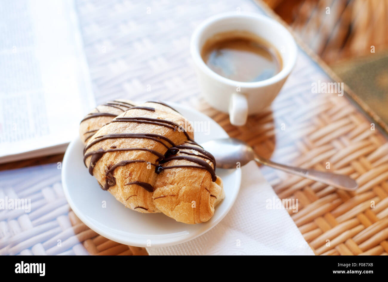 Tasse Kaffee und ein Croissant auf dem Tisch Stockfoto