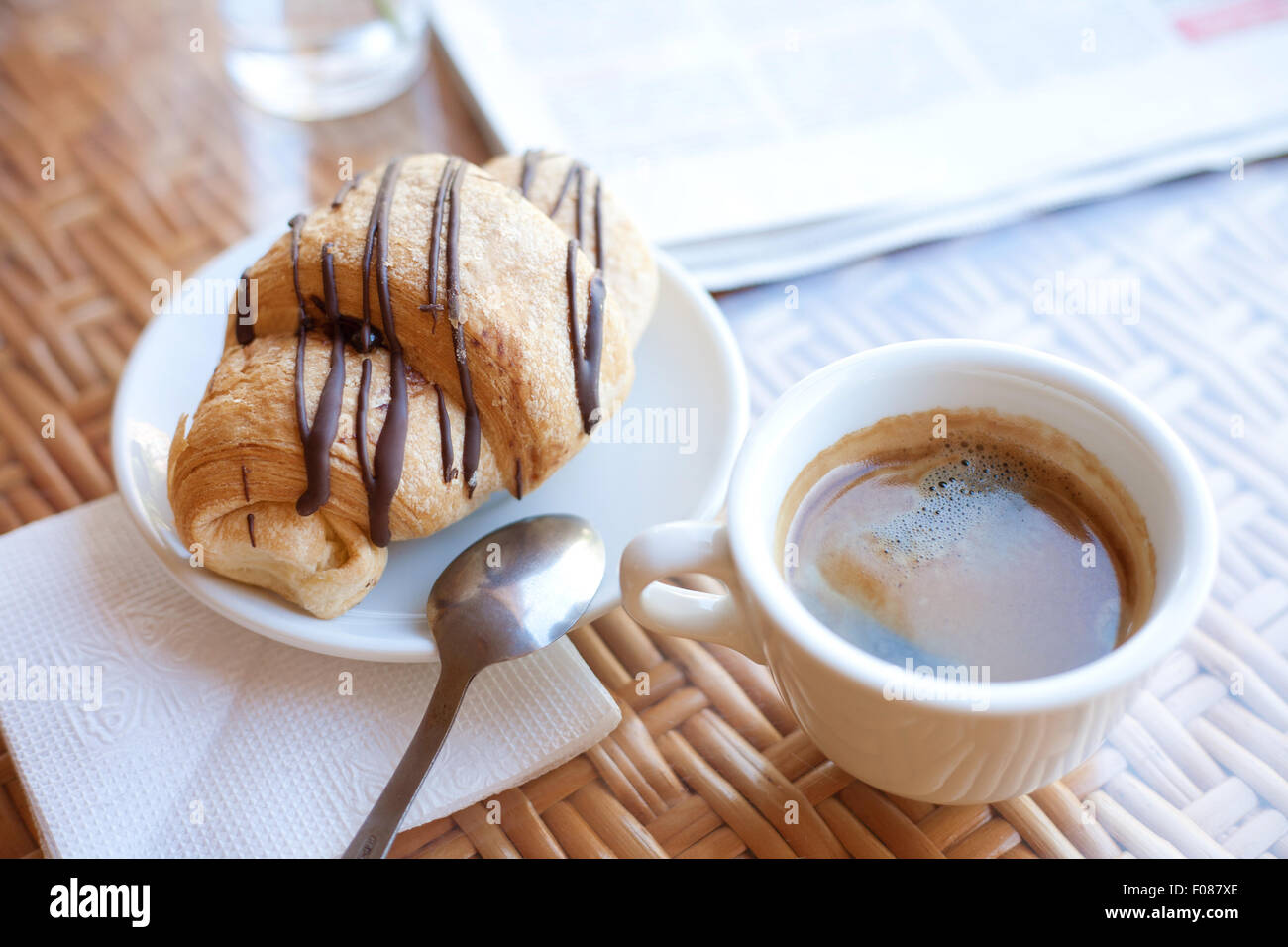Tasse Kaffee und ein Croissant auf dem Tisch Stockfoto