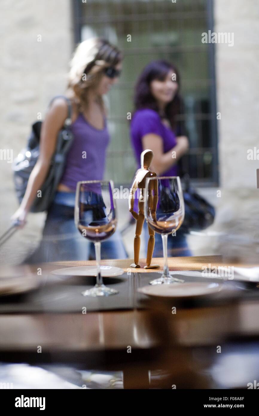 Zwei Gläser Wein am Tisch, während zwei Frauen zu Fuß an der Costa Brava Stockfoto