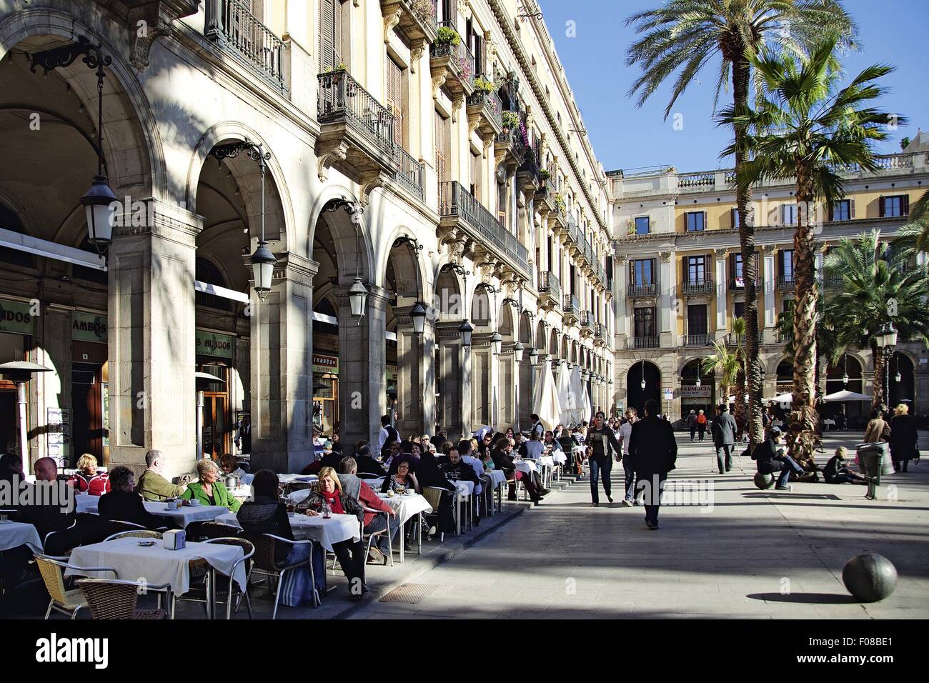 Personen an Tischen außerhalb Cafés am Placa Reial Square, Barcelona, Katalonien, Spanien Stockfoto