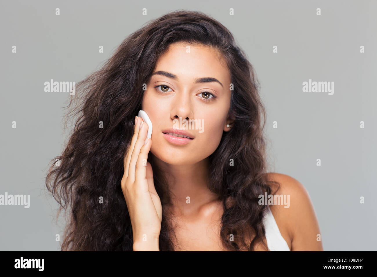 Beauty Portrait eine junge nette Frau mit wattierte Datenträger auf grauem Hintergrund. Blick in die Kamera Stockfoto