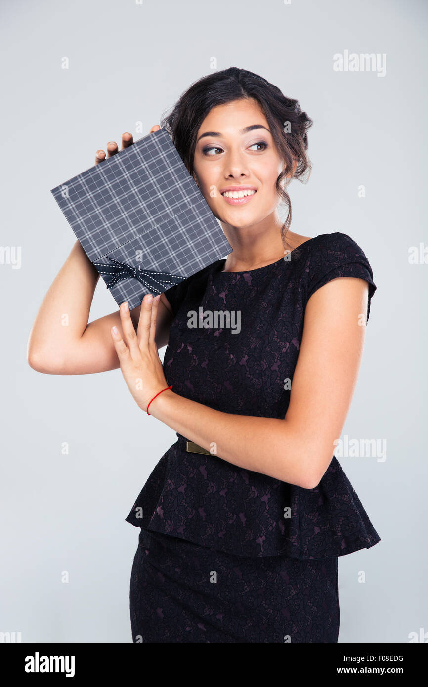 Lächelnd Mode Frau mit Geschenk-Box auf grauem Hintergrund Stockfoto