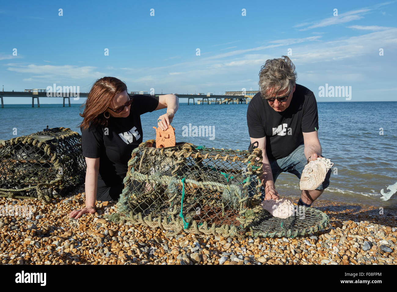 Deal, Kent, Großbritannien, Sonntag, 9. August 2015. Kate Davis und David Moore auf Deal Beach das Motto "Cabbo' Masken in Hummer Töpfe am letzten Abend der Deal Pier Kunst Veranstaltung. Der Hummer Töpfe mit den Masken wird später in das Meer, das im kommenden Jahr abgerufen werden abgesenkt werden. Dies folgt der alten Tradition des Cabbo. Die Masken wurden aus dem Meer gesammelt nach einem Jahr, und denen, die unversehrt überlebten, wurden die Boote der Fischer wie viel Glück Talismane befestigt. Quelle: Steve Hickey/Alamy leben Nachrichten Stockfoto