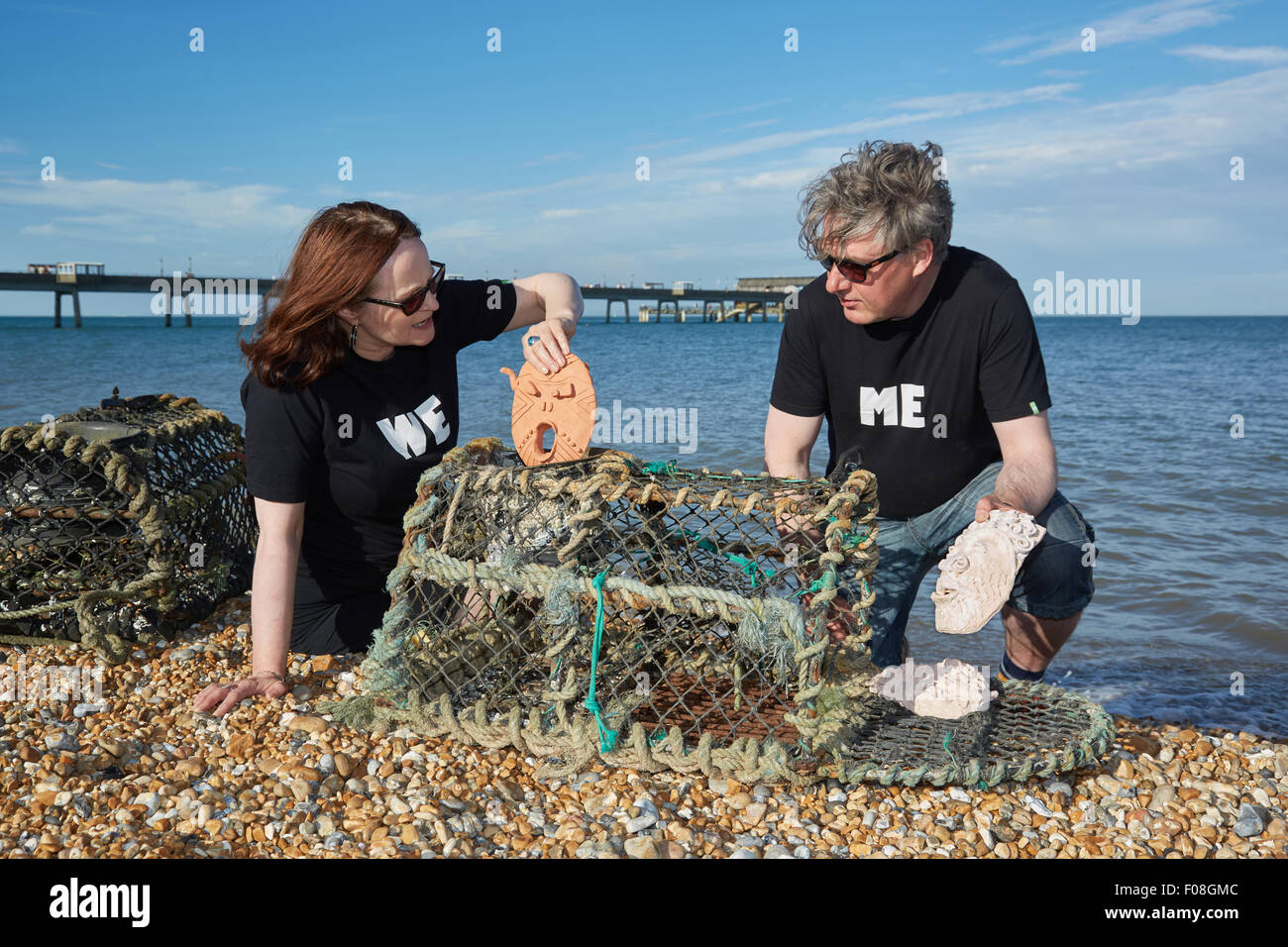 Deal, Kent, Großbritannien, Sonntag, 9. August 2015. Kate Davis und David Moore auf Deal Beach das Motto "Cabbo' Masken in Hummer Töpfe am letzten Abend der Deal Pier Kunst Veranstaltung. Der Hummer Töpfe mit den Masken wird später in das Meer, das im kommenden Jahr abgerufen werden abgesenkt werden. Dies folgt der alten Tradition des Cabbo. Die Masken wurden aus dem Meer gesammelt nach einem Jahr, und denen, die unversehrt überlebten, wurden die Boote der Fischer wie viel Glück Talismane befestigt. Quelle: Steve Hickey/Alamy leben Nachrichten Stockfoto