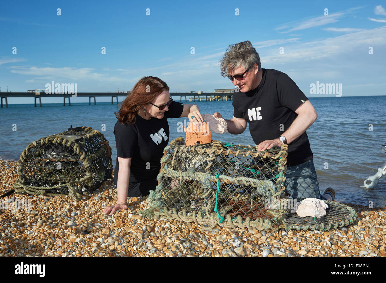 Deal, Kent, Großbritannien, Sonntag, 9. August 2015. Kate Davis und David Moore auf Deal Beach das Motto "Cabbo' Masken in Hummer Töpfe am letzten Abend der Deal Pier Kunst Veranstaltung. Der Hummer Töpfe mit den Masken wird später in das Meer, das im kommenden Jahr abgerufen werden abgesenkt werden. Dies folgt der alten Tradition des Cabbo. Die Masken wurden aus dem Meer gesammelt nach einem Jahr, und denen, die unversehrt überlebten, wurden die Boote der Fischer wie viel Glück Talismane befestigt. Quelle: Steve Hickey/Alamy leben Nachrichten Stockfoto