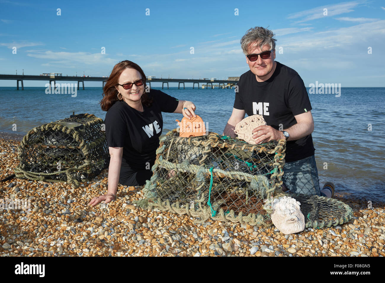 Deal, Kent, Großbritannien, Sonntag, 9. August 2015. Kate Davis und David Moore auf Deal Beach das Motto "Cabbo' Masken in Hummer Töpfe am letzten Abend der Deal Pier Kunst Veranstaltung. Der Hummer Töpfe mit den Masken wird später in das Meer, das im kommenden Jahr abgerufen werden abgesenkt werden. Dies folgt der alten Tradition des Cabbo. Die Masken wurden aus dem Meer gesammelt nach einem Jahr, und denen, die unversehrt überlebten, wurden die Boote der Fischer wie viel Glück Talismane befestigt. Quelle: Steve Hickey/Alamy leben Nachrichten Stockfoto