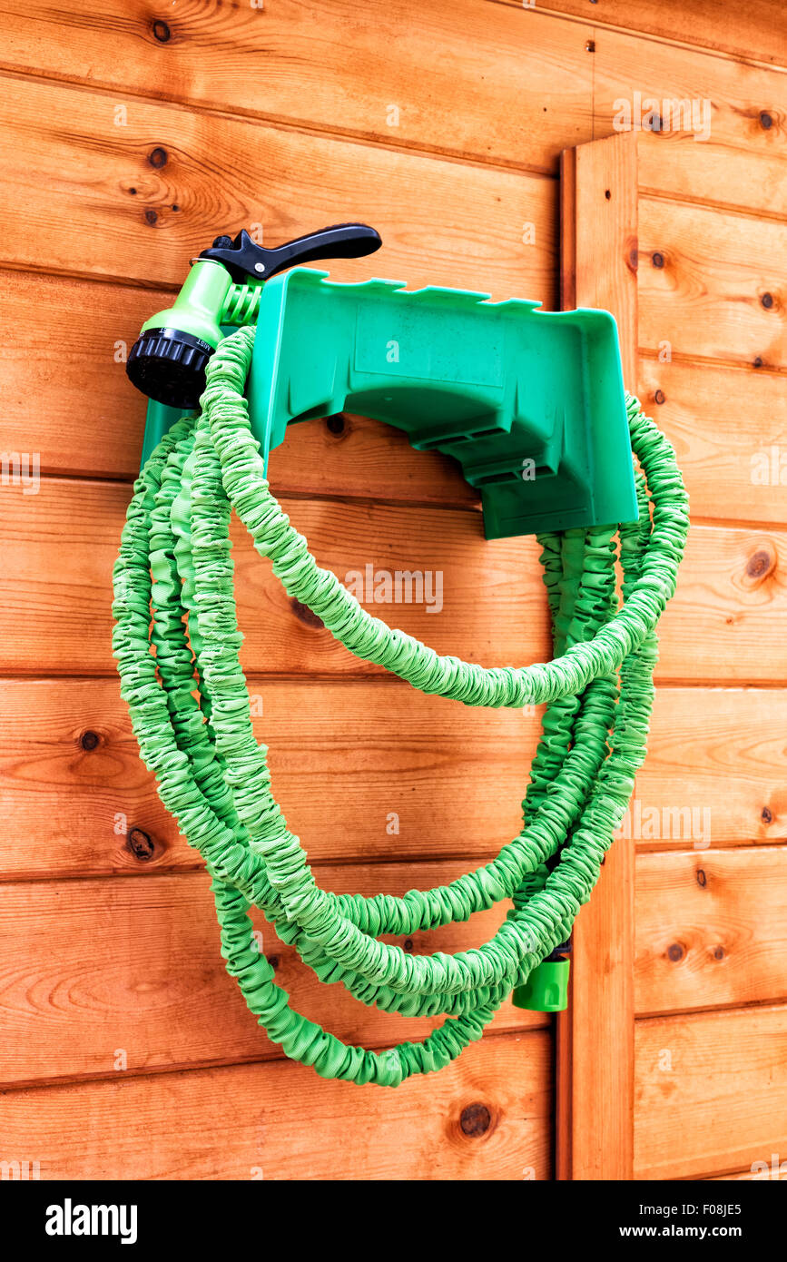 Nicht knicken grünen Garten Schlauch hängen an der Seite einen Schuppen Stockfoto