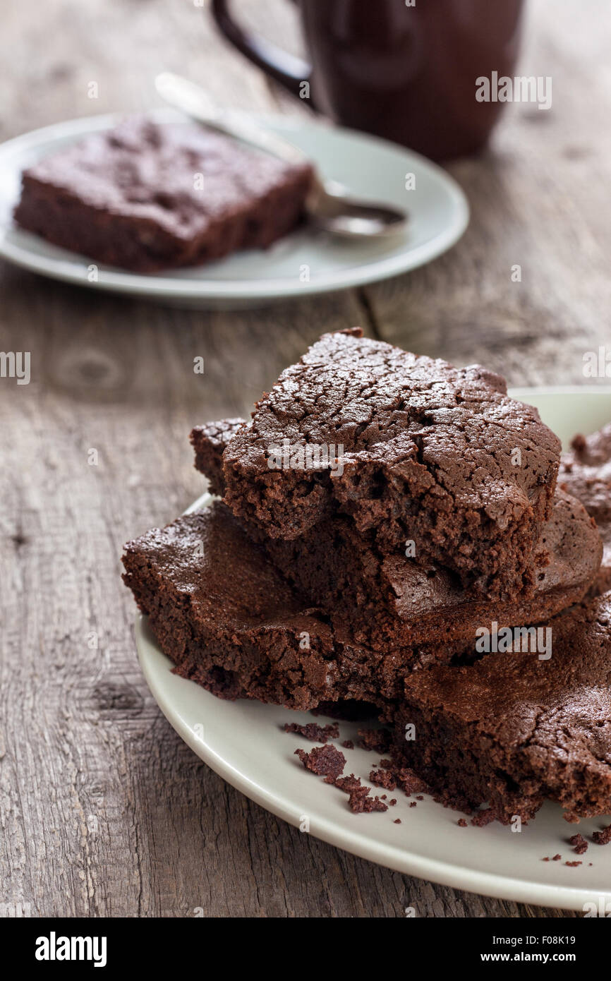 Schokoladen-Brownie und Tasse Tee auf einem hölzernen Hintergrund Stockfoto