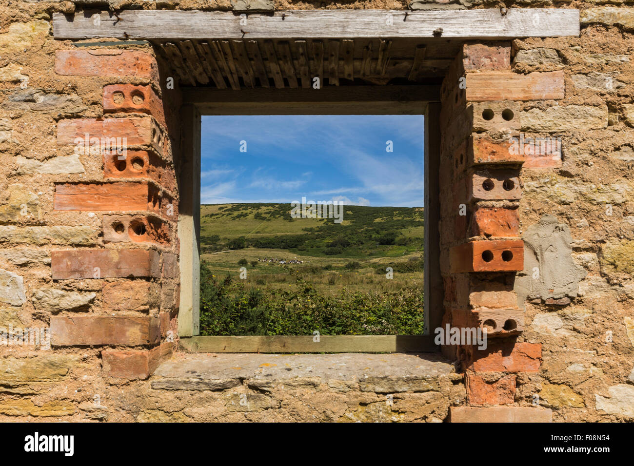 Die Dorset Landschaft durch das Fenster des Haus des Gärtners in der Ghost Dorf Bucht, Dorset, England Stockfoto