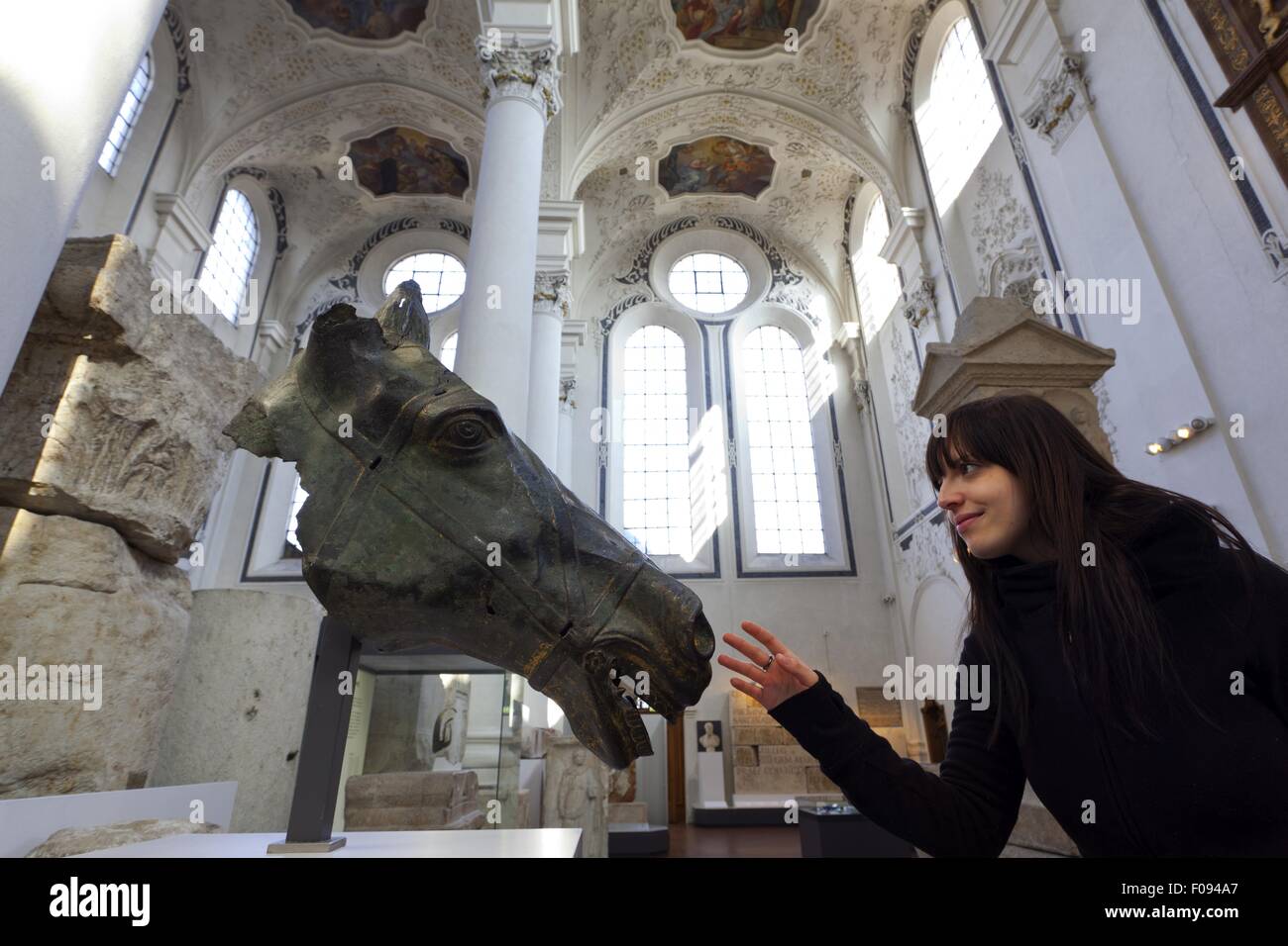 Frau berühren Bronze Pferdekopf im römischen Museum Hallenkirche, Augsburg, Deutschland Stockfoto