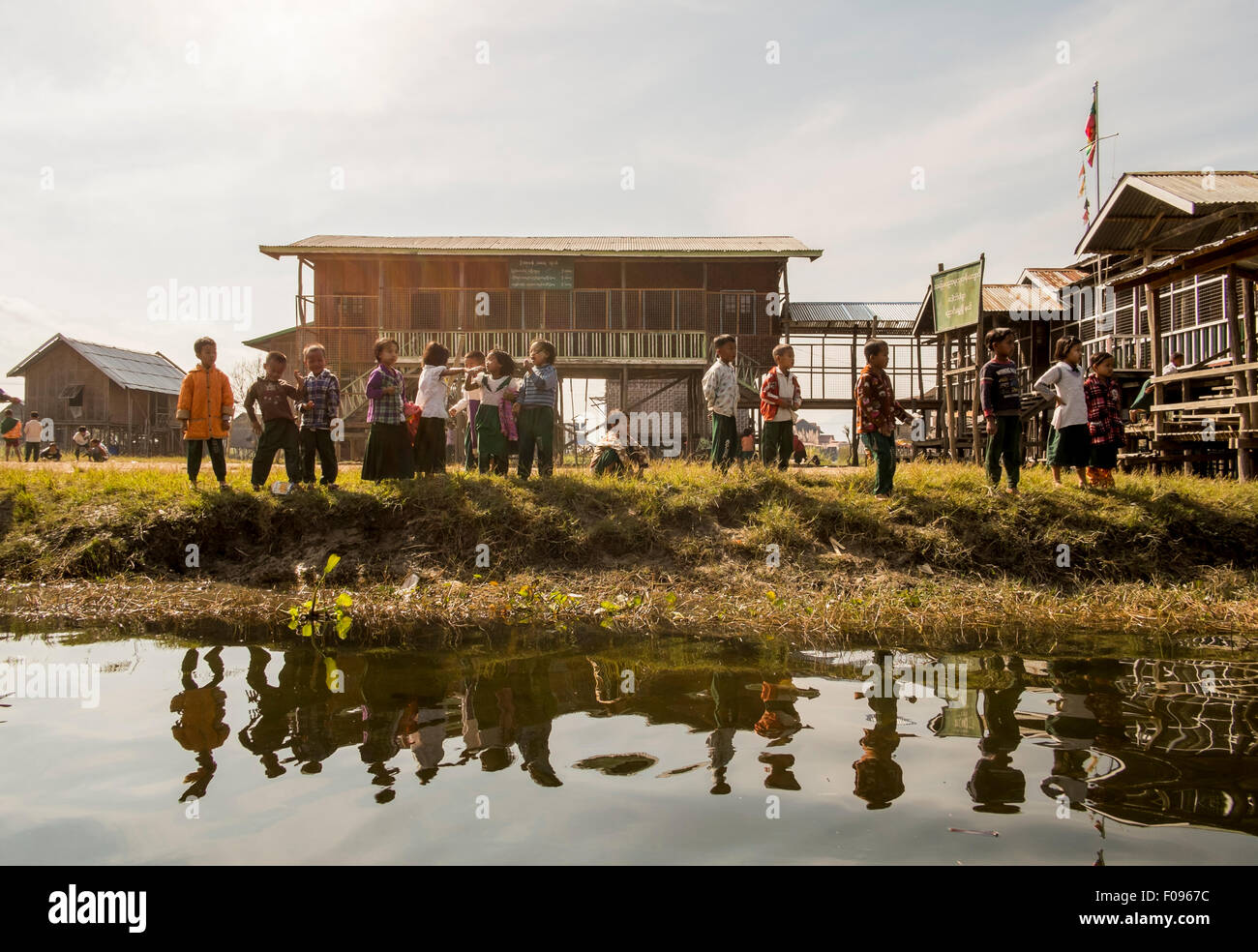 Inle-See, Myanmar (Burma) Kinder spielen am Ufer der Wasserstraße in Inle-See, Myanmar Stockfoto