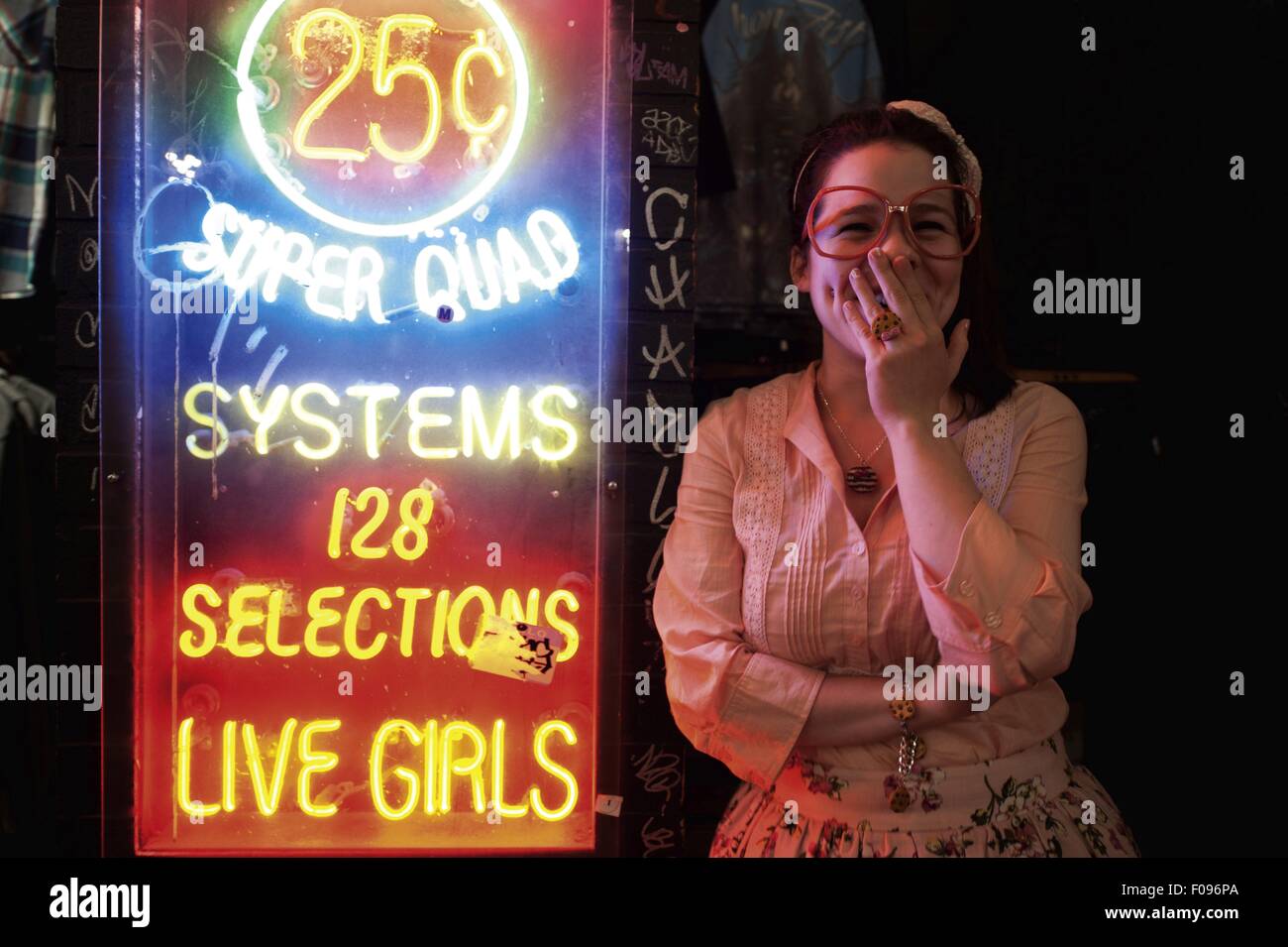 Neben kommerziellen Leuchtreklame in Broadway, SoHo, Manhattan, New York, USA lachende Frau Stockfoto