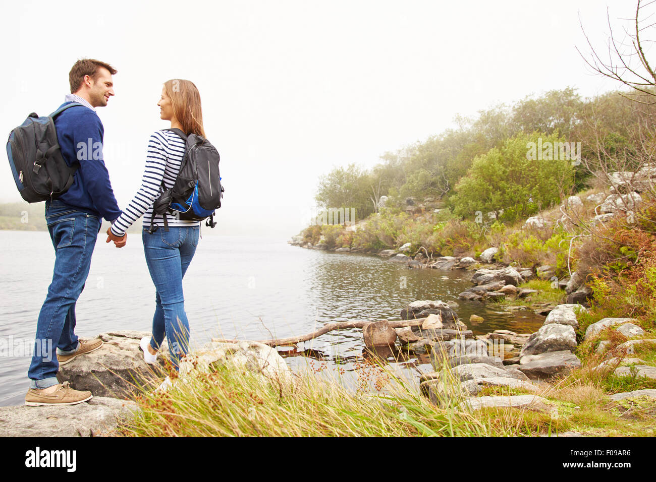 Junges Paar stehend an einem See, sahen einander Stockfoto